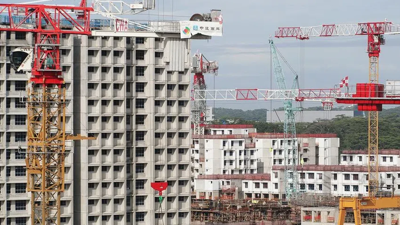 Tower cranes and a Housing Board block under construction, illustrating the pace of building work ahead of a BTO launch.