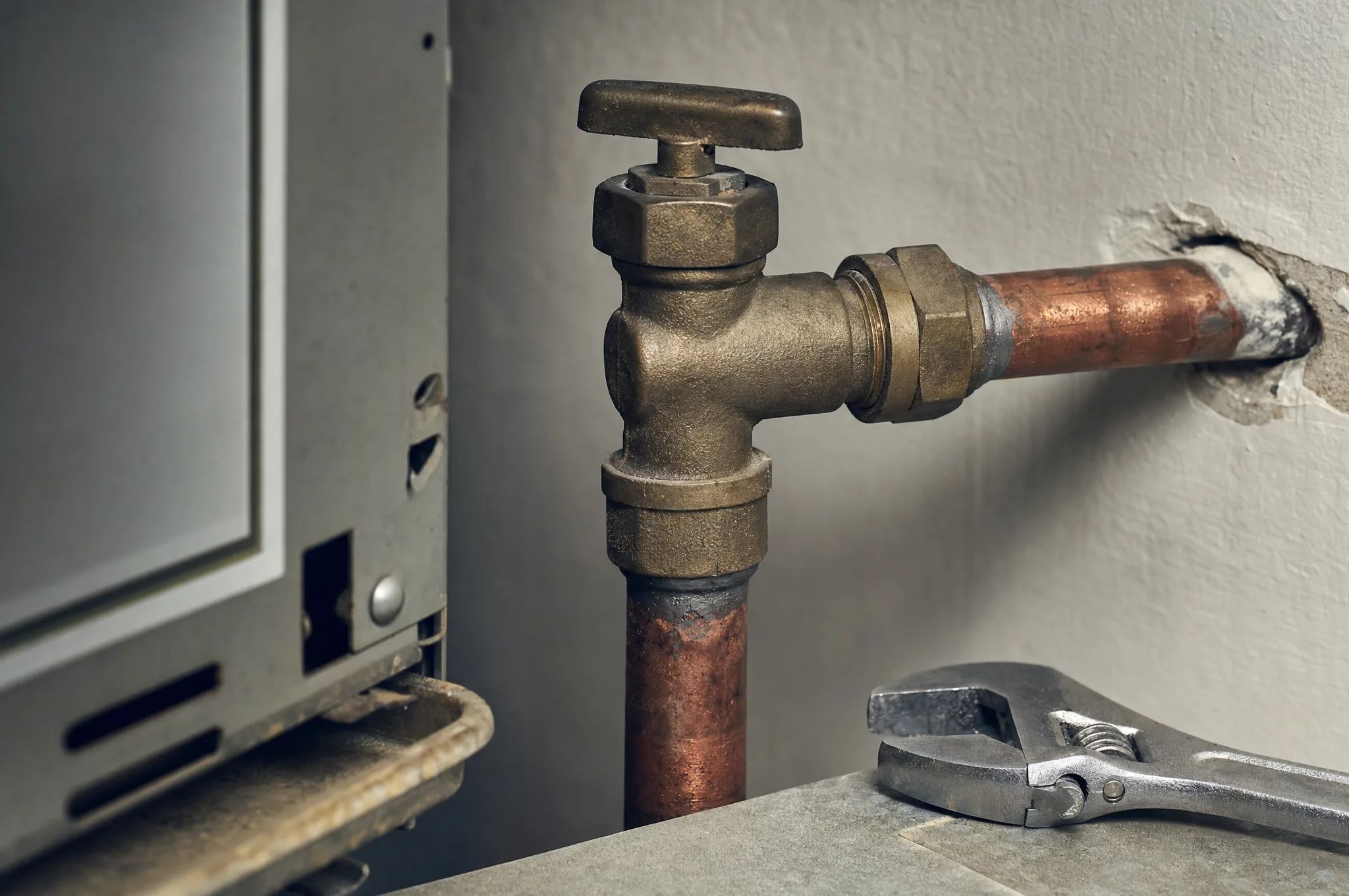 Editorial illustration: a close-up of a gas pipe fitting and valve with a wrench resting nearby